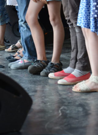 photo de pieds d'enfants sur scène illustrant l'article sur le CLEA de Lons-le-Saunier